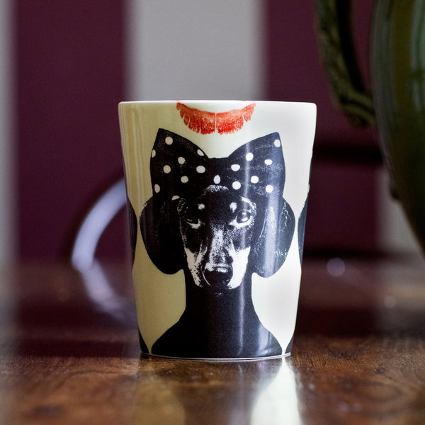 Designmugg ‘Tillsammans’ av Lisa Bengtsson – pastellgrön med svart hund och fluga, närbild med läppstiftsmärke på kanten