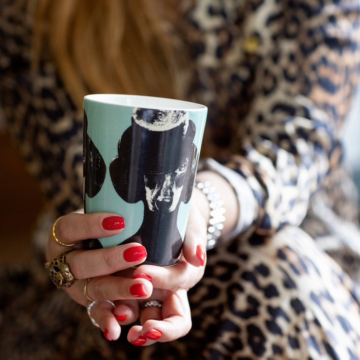 Närbild på Lisa Bengtssons hand som håller en mugg ur serien Tillsammans från ICONCUPS.