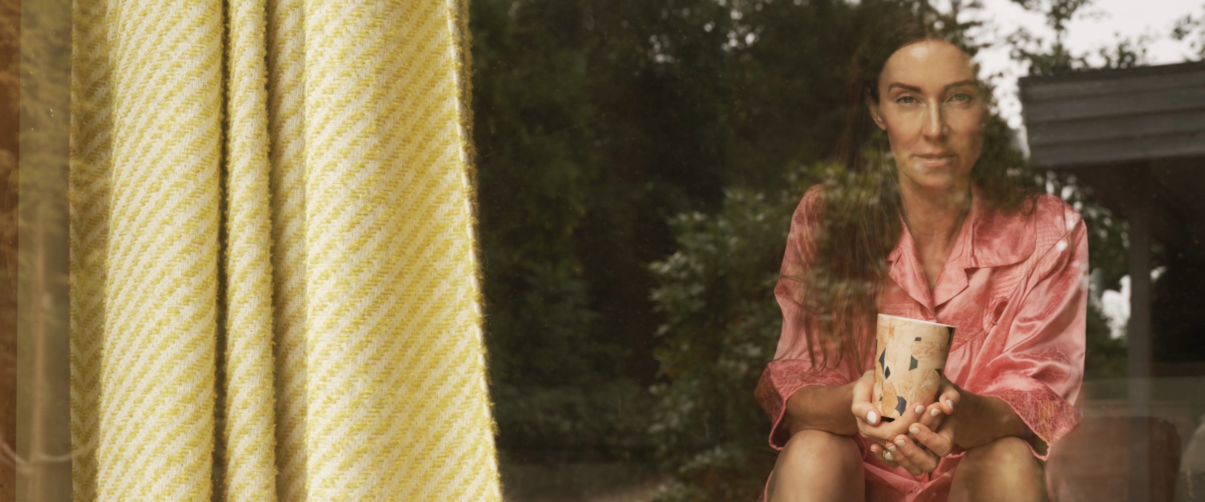 Bannerbild på Marie Olsson Nylander i sitt hem med ICONCUPS-mugg i famnen.