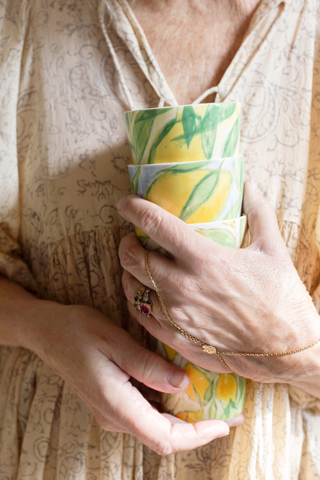 Närbild på Lena Linderholm som håller benporslinsmuggar med citronmotiv ur serien Citrons de Provence för ICONCUPS
