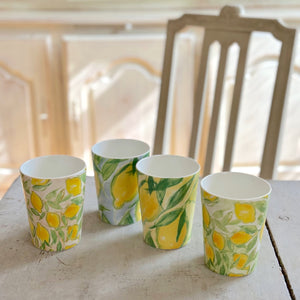 Muggar från serien ‘Citrons de Provence’ av Lena Linderholm – uppställda på bord med stol och vitrinskåp i bakgrunden